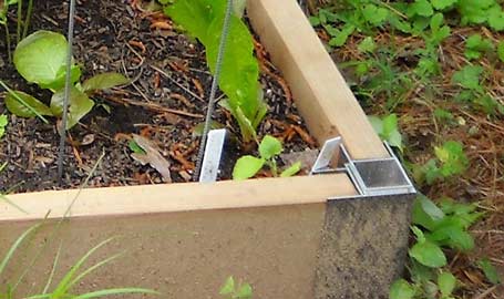 Hardware anchors the side of a raised bed
